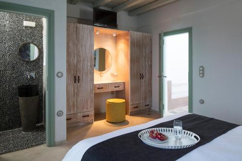 a bedroom with a bed with a plate of fruit on it at Melograno Villas in Astypalaia Town