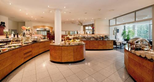 Ringhotel Am Stadtpark في لونن: مطعم مع بار مع مجموعة من الطعام