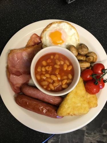 a plate of breakfast food with sausage beans eggs and mushrooms at The Windsor Carlton in Blackpool