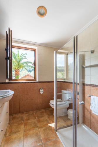 a bathroom with a shower and a toilet and a window at Casa Madrazo con piscina y parrillas in Praves