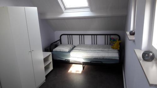 - une petite chambre avec un lit et une fenêtre dans l'établissement Duinnachtegaal, à Egmond aan Zee