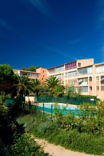une piscine devant un immeuble dans l'établissement Vacancéole - La Baie des Anges, au Cap d'Agde