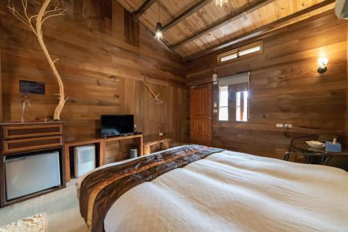 a bedroom with wooden walls and a large bed at Shankou Hotspring Hotel in Jiaoxi