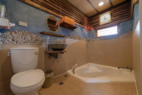 a bathroom with a toilet and a bath tub at Shankou Hotspring Hotel in Jiaoxi