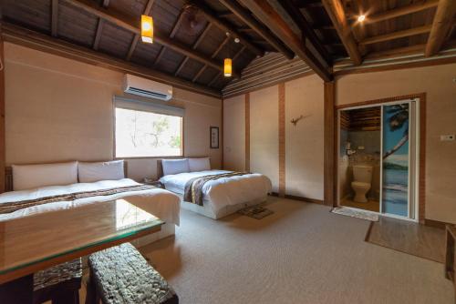 a bedroom with two beds and a couch and a window at Shankou Hotspring Hotel in Jiaoxi