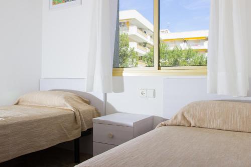 1 dormitorio con 2 camas y ventana en Cala Dorada Rentalmar, en Salou