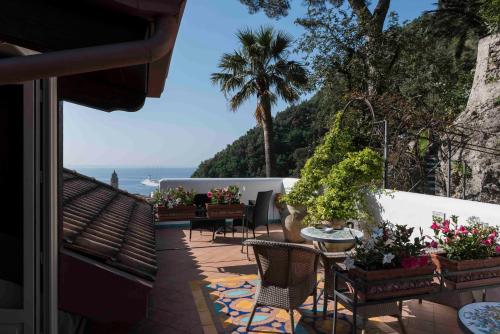 a balcony with tables and chairs and a view of the ocean at Hotel Villa Annalara charme and Relax in Amalfi