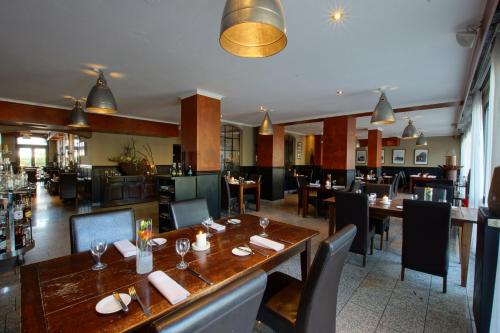a dining room with tables and chairs and a restaurant at Hotel Dampfmühle in Neukirchen-Vluyn