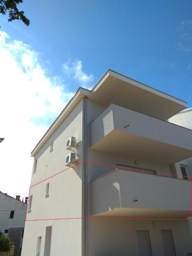 a white building with red lines on the side of it at Apartment Domagoj, Novalja,with 3 air conditioning units in Novalja