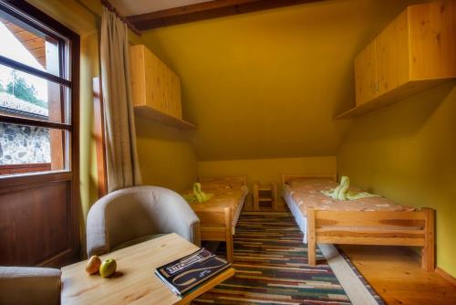 two tables and chairs in a room with yellow walls at Chata Piecky in Hrabušice