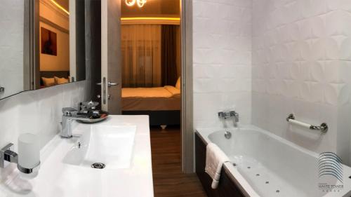 a bathroom with a sink and a bath tub at White Tower Mamaia in Mamaia