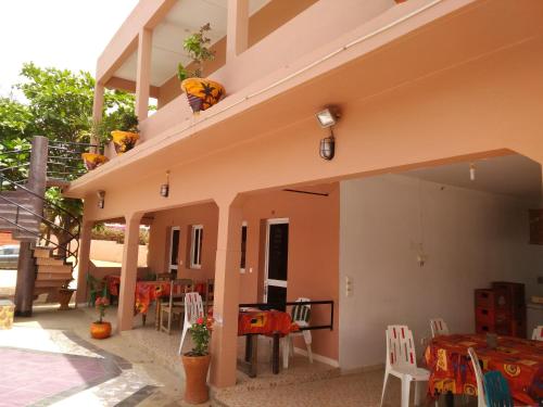 a patio with tables and chairs and a building at Africa 6 Plage in Somone