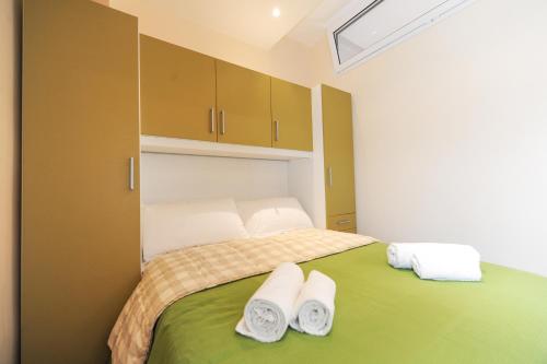 ニースにあるSuite Halevy 5 stars Holiday Houseのベッドルーム1室(緑色のベッド1台、タオル付)