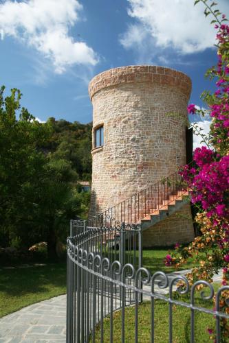 a brick tower with a fence in front of it at Residence Mare e Monte in Favone