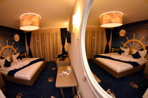 a hotel room with two beds and a mirror at Pirates Resort in Mamaia