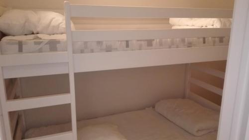 コクセッドにあるCap Horn 0205の白い二段ベッドが備わる小さな客室です。