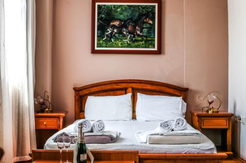 a bedroom with a bed with a picture on the wall at Hotel Premier Centar in Bitola