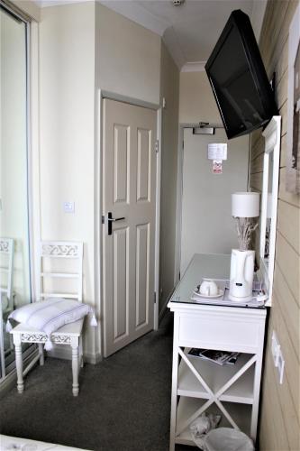 a room with a door and a table with a television at Seascale Hotel & Restaurant in Gorey