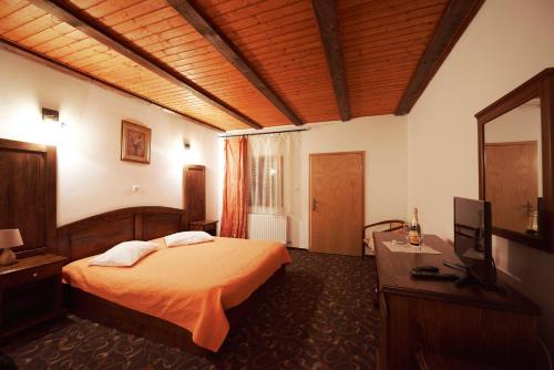 a bedroom with a bed and a flat screen tv at Drumul Dragostei in Vintu De Jos