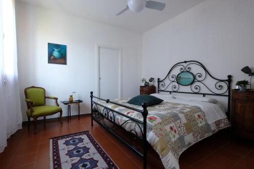 a bedroom with a bed and a green chair at Casa Monteluro - B&b in Tavullia
