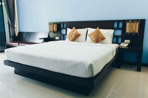 a bedroom with a large white bed with pillows at Palm Sweet Resort in Chumphon