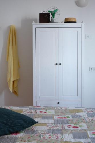 a bedroom with a white cabinet and a bed at Casa Monteluro - B&b in Tavullia