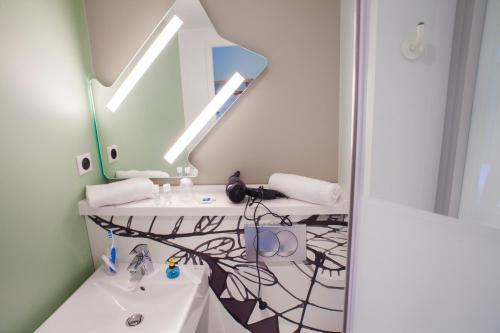 a bathroom with a sink and a mirror at ibis budget Bordeaux Est Lormont in Lormont