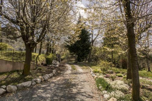 a path in a park with trees and a fence at B&B Il Mirtillo in Moncrivello