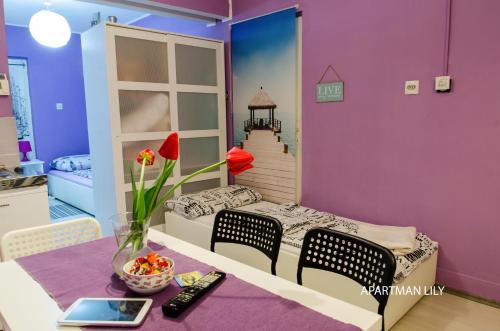 a room with a bed and a table with a vase of flowers at Apartments Kamenecki in Krapina