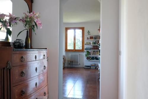 a hallway with a dresser with flowers on top of it at Casa Monteluro - B&b in Tavullia
