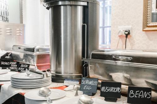 格拉斯哥的住宿－安吉爾酒店，厨房在柜台上摆放盘子和勺子