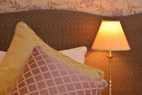 a lamp sitting next to a bed with a pillow at The Devonshire Grassington in Grassington