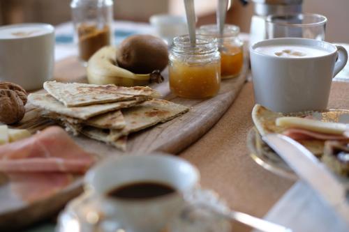 a table with a plate of food and cups of coffee at Casa Monteluro - B&b in Tavullia