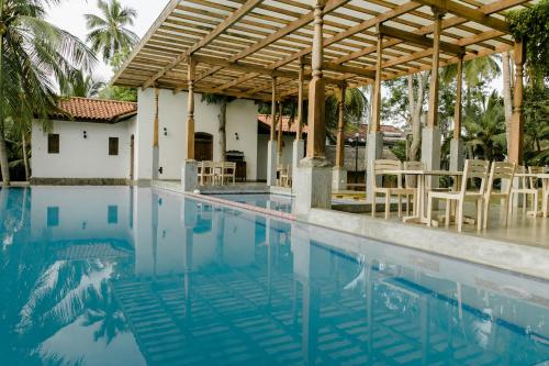a swimming pool in front of a house at Nuga Eden Tangalle in Tangalle