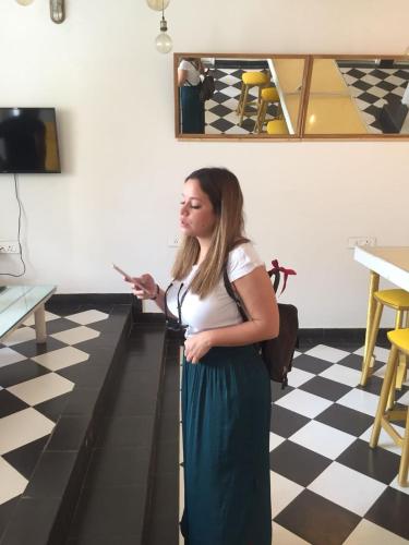 a woman standing in a room holding a cell phone at Stay Banaras - A Boutique Hotel in Varanasi