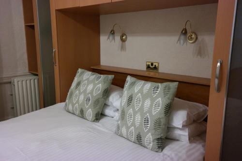a bedroom with a bed with two white pillows at Arrandale Apartments in Douglas