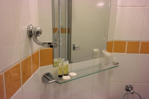 a bathroom with a glass shelf and a mirror at Arrandale Apartments in Douglas