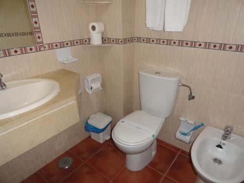 a bathroom with a white toilet and a sink at Alagoa Azul II in Altura