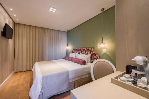 a hotel room with a large bed and a table at Araçatuba Plaza Hotel in Araçatuba