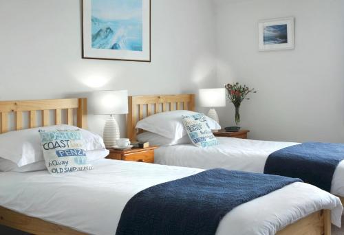 um quarto com 2 camas e 2 almofadas em Surf Haven em Bude