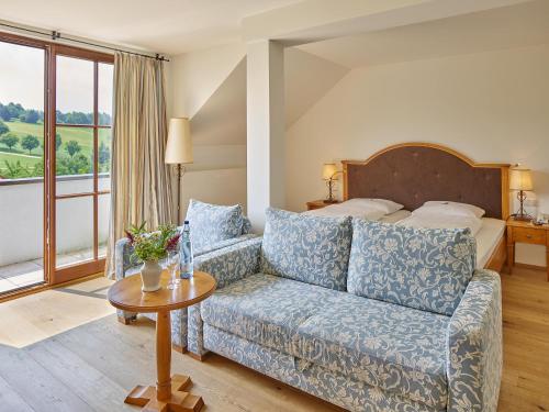 a living room with a couch and a bed at Gutshof Uttlau in Haarbach