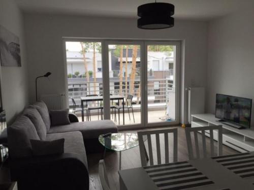 a living room with a couch and a table at Apartament Baltic Park in Pogorzelica