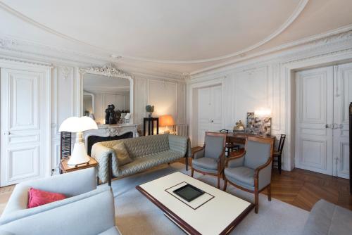 パリにあるVeeve - Charming Haussmannianのリビングルーム(ソファ、椅子、テーブル付)