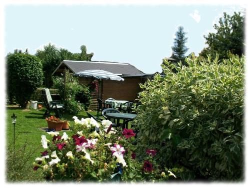 a garden with a table and chairs and flowers at Fewo Hoyer in Hinterhermsdorf