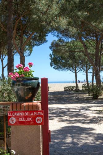 a sign at the beach with a vase of flowers at Grand Hôtel Du Lido in Argelès-sur-Mer