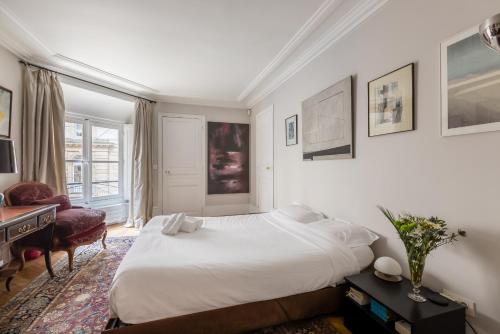 a bedroom with a large white bed and a desk at Veeve - Latin Quarter Retreat in Paris