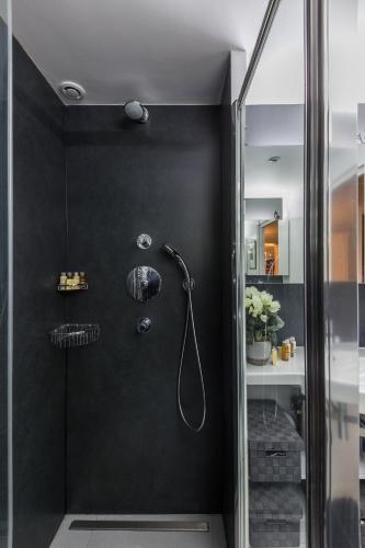 La salle de bains est pourvue d'une douche et d'un mur noir. dans l'établissement Veeve - Latin Quarter Retreat, à Paris