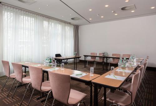 a conference room with tables and chairs and curtains at ibis Styles Hotel Gelsenkirchen in Gelsenkirchen
