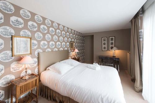 a bedroom with a bed and a wall with plates at Veeve - Steps from the Eiffel Tower in Paris