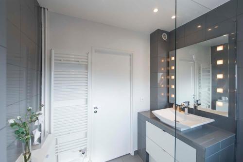 a bathroom with a sink and a mirror at Veeve - Steps from the Eiffel Tower in Paris